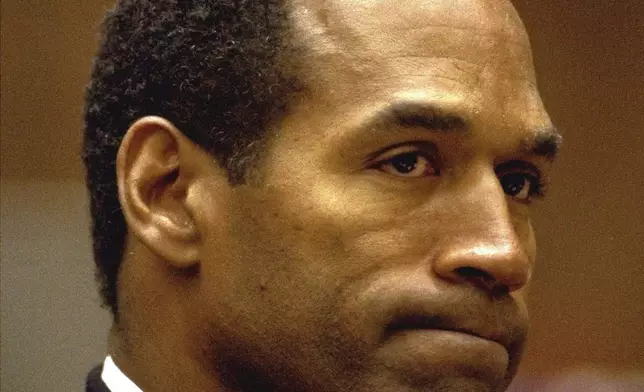 FILE - O.J. Simpson bites his lip Friday, July 8, 1994, as he listens to Dr. Irwin L. Golden, a medical examiner, describe the extent of Nicole Simpson Brown's wounds during testimony in Los Angeles Criminal Courts. Simpson, the decorated football superstar and Hollywood actor who was acquitted of charges he killed his former wife and her friend but later found liable in a separate civil trial, has died. He was 76. (AP Photo/Eric Draper, File)