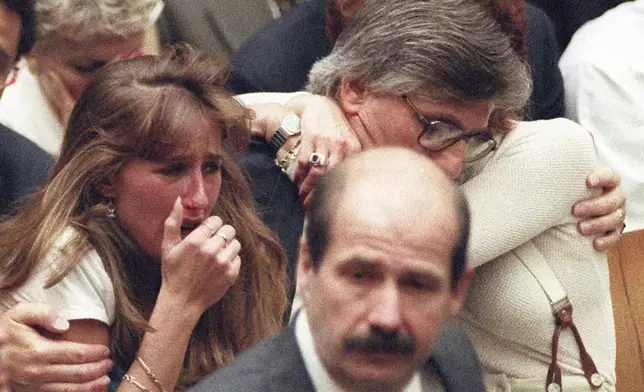 FILE - Fred Goldman, father of Ron Goldman, hugs his wife Patti, as his daughter, Kim, left, reacts during the reading of the not guilty verdicts in O.J. Simpson double-murder trial in Tuesday, Oct. 3,1995, in Los Angeles. Simpson was acquitted in the murders of Goldman and Simpson's ex-wife Nicole. Foreground is Los Angeles Police Detective Tom Lange, co-lead investigator in the case. Simpson, the decorated football superstar and Hollywood actor who was acquitted of charges he killed his former wife and her friend but later found liable in a separate civil trial, has died. He was 76. (Myung J. Chun/Los Angeles Daily News via AP, Pool, File)