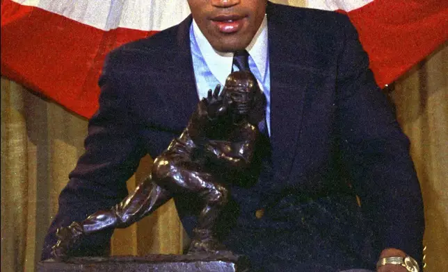 FILE - Southern Cal's O.J. Simpson poses with the Heisman Trophy at New York's Downtown Athletic Club, Dec. 5, 1968. O.J. Simpson, the decorated football superstar and Hollywood actor who was acquitted of charges he killed his former wife and her friend but later found liable in a separate civil trial, has died. He was 76. Simpson's attorney confirmed to TMZ he died Wednesday night, April 10, 2024, in Las Vegas. (AP Photo/File)