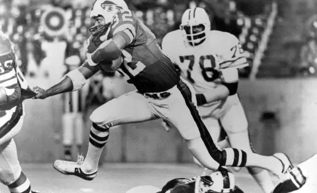 FILE - Buffalo Bills runningback O.J. Simpson (32) runs over some teammates as he latches onto Joe DeLamielleurs (68) during an NFL football game against the Tampa Bay Buccaneers at Rich Stadium in Buffalo, N.Y., Sept. 3, 1977. Buccaneers Council Rudolph (78) follows at right. (AP Photo/File)