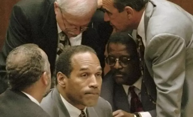 FILE - O.J. Simpson is surrounded by his defenseattorneys, clockwise from left, Ken Spaulding, back towards camera, Gerald Uelmen, Robert Shapiro and Johnnie Cochran Jr., as they discuss their plans for arguing the admissibility of the tapes of retired Los Angeles police detective Mark Fuhrman during his trial, Tuesday, Aug. 29, 1995 in Los Angeles. Simpson, the decorated football superstar and Hollywood actor who was acquitted of charges he killed his former wife and her friend but later found liable in a separate civil trial, has died. He was 76. (Myung J. Chun/Los Angeles Daily News via AP, Pool, File)