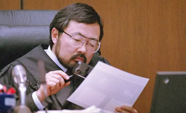 FILE - Judge Lance Ito views evidence with a magnifying glass during O.J. Simpson's double-murder trial, Aug. 25, 1995, in Los Angeles. Simpson, the decorated football superstar and Hollywood actor who was acquitted of charges he killed his former wife and her friend but later found liable in a separate civil trial, has died. He was 76. (AP Photo/Pool/Mark J. Terrill, File)