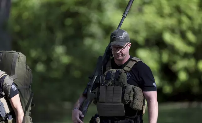 A law officer walks away from the scene of a shooting where multiple law enforcement officers were shot while serving a warrant for a felon wanted for possessing a firearm in Charlotte, N.C., on Monday, April 29, 2024. (Khadejeh Nikouyeh/The Charlotte Observer via AP)