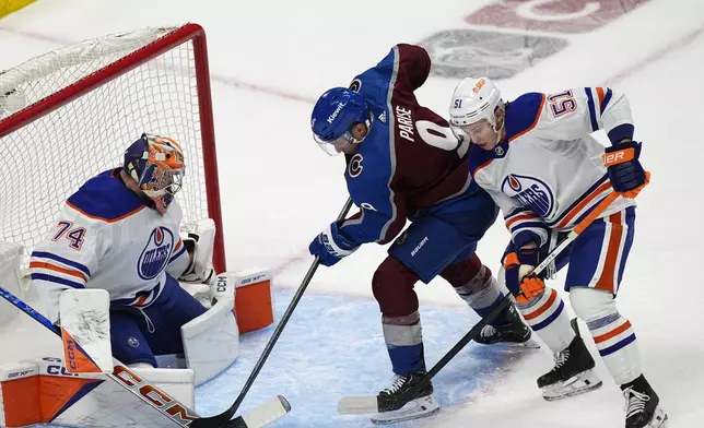 Colorado Avalanche left wing Zach Parise, center, puts a shot on Edmonton Oilers goaltender Stuart Skinner, left, after driving past defenseman Troy Stecher during the first period of an NHL hockey game Thursday, April 18, 2024, in Denver. (AP Photo/David Zalubowski)