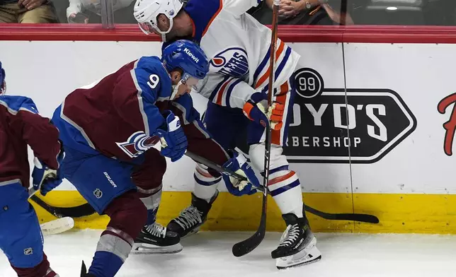 Colorado Avalanche left wing Zach Parise, left, and Edmonton Oilers center Derek Ryan work for the puck during the first period of an NHL hockey game Thursday, April 18, 2024, in Denver. (AP Photo/David Zalubowski)