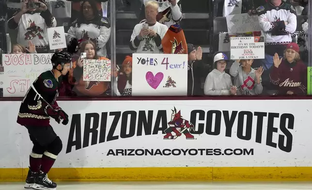 Arizona Coyotes' Dylan Guenther skates past fans as players warm up for an NHL hockey game against the Edmonton Oilers on Wednesday, April 17, 2024, in Tempe, Ariz. The Coyotes are moving to Salt Lake City in a deal that could be signed less than 24 hours after the game. Hockey could return, perhaps within five years, but the stark reality is this is the end for the foreseeable future. (AP Photo/Ross D. Franklin)