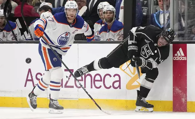 Los Angeles Kings center Anze Kopitar, right, passes the puck while under pressure from Edmonton Oilers center Connor McDavid during the second period in Game 4 of an NHL hockey Stanley Cup first-round playoff series Sunday, April 28, 2024, in Los Angeles. (AP Photo/Mark J. Terrill)