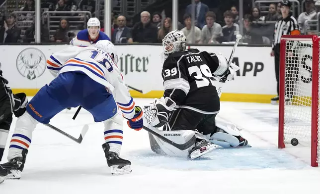 Edmonton Oilers left wing Zach Hyman, left, scores on Los Angeles Kings goaltender Cam Talbot during the third period in Game 3 of an NHL hockey Stanley Cup first-round playoff series Friday, April 26, 2024, in Los Angeles. (AP Photo/Mark J. Terrill)