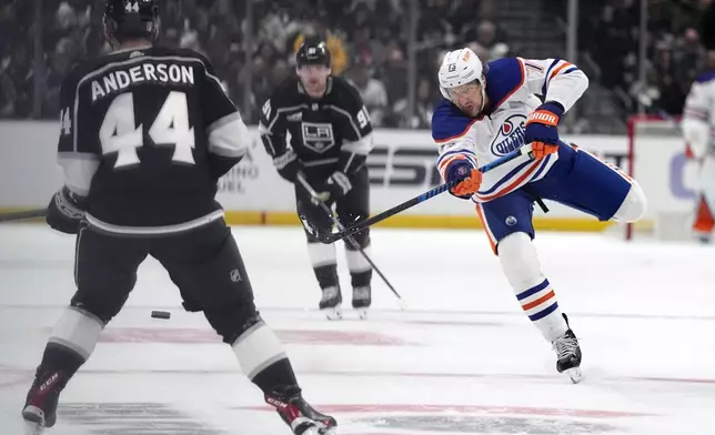 Edmonton Oilers defenseman Vincent Desharnais, right, passes the puck while under pressure from Los Angeles Kings defenseman Mikey Anderson aduring Game 3 of an NHL hockey Stanley Cup first-round playoff series Friday, April 26, 2024, in Los Angeles. (AP Photo/Mark J. Terrill)