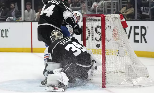 Los Angeles Kings goaltender Cam Talbot, center, is scored on by Edmonton Oilers left wing Zach Hyman, right, as defenseman Mikey Anderson defends during Game 3 of an NHL hockey Stanley Cup first-round playoff series Friday, April 26, 2024, in Los Angeles. (AP Photo/Mark J. Terrill)
