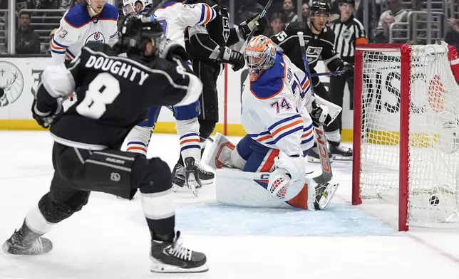Los Angeles Kings defenseman Drew Doughty, left, scores on Edmonton Oilers goaltender Stuart Skinner during the second period in Game 3 of an NHL hockey Stanley Cup first-round playoff series Friday, April 26, 2024, in Los Angeles. (AP Photo/Mark J. Terrill)