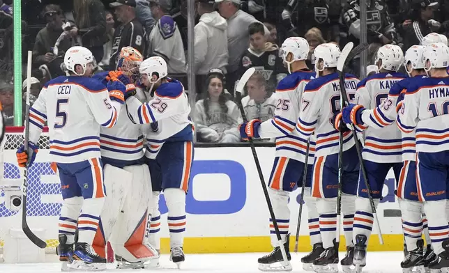 Edmonton Oilers defenseman Cody Ceci (5) and center Leon Draisaitl (29) congratulate goaltender Stuart Skinner (74) after the Oilers defeated the Los Angeles Kings 1-0 in Game 4 of an NHL hockey Stanley Cup first-round playoff series Sunday, April 28, 2024, in Los Angeles. (AP Photo/Mark J. Terrill)