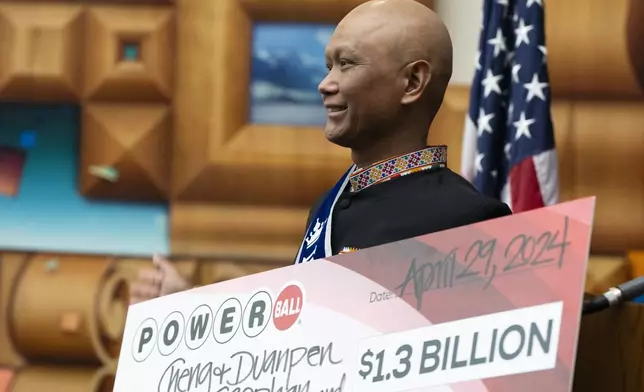 Cheng "Charlie" Saephan holds display check before speaking during a news conference where it was revealed that he was one of the winners of the $1.3 billion Powerball jackpot at the Oregon Lottery headquarters on Monday, April 29, 2024, in Salem, Ore. (AP Photo/Jenny Kane)