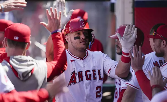 Los Angeles Angels designated hitter Mike Trout celebrates in the dugout after hitting a home run during the sixth inning of a baseball game against the Baltimore Orioles in Anaheim, Calif., Wednesday, April 24, 2024. (AP Photo/Ashley Landis)