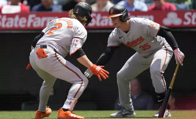 Baltimore Orioles' Gunnar Henderson (2) celebrates with designated hitter Adley Rutschman (35) after hitting a home run during the third inning of a baseball game against the Los Angeles Angels in Anaheim, Calif., Wednesday, April 24, 2024. (AP Photo/Ashley Landis)