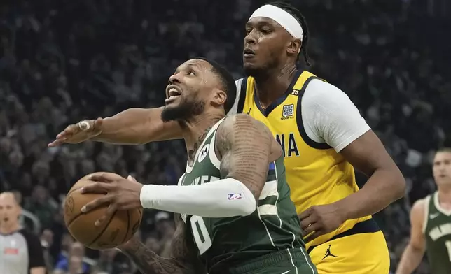 Milwaukee Bucks' Damian Lillard gets past Indiana Pacers' Myles Turner during the first half of Game 1 of the NBA playoff basketball game Sunday, April 21, 2024, in Milwaukee. (AP Photo/Morry Gash)