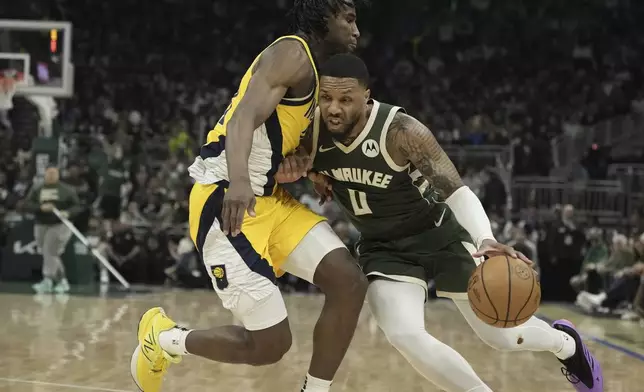 Milwaukee Bucks' Damian Lillard gets past Indiana Pacers' Aaron Nesmith during the first half of Game 1 of the NBA playoff basketball game Sunday, April 21, 2024, in Milwaukee. (AP Photo/Morry Gash)