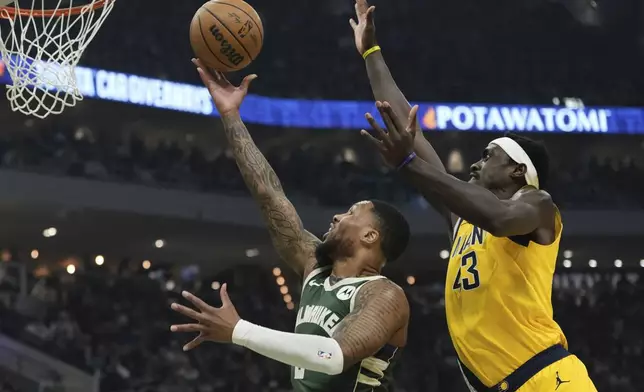Indiana Pacers' Pascal Siakam blocks the shot of Milwaukee Bucks' Damian Lillard during the first half of Game 1 of the NBA playoff basketball game Sunday, April 21, 2024, in Milwaukee. (AP Photo/Morry Gash)