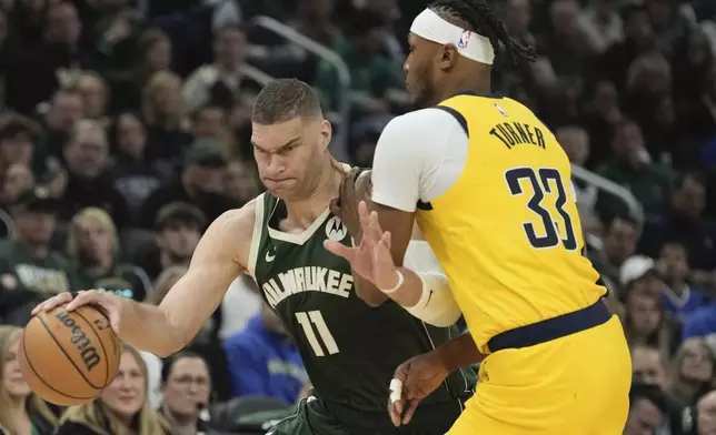 Milwaukee Bucks' Brook Lopez tries to get by Indiana Pacers' Myles Turner during the first half of Game 1 of the NBA playoff basketball game Sunday, April 21, 2024, in Milwaukee. (AP Photo/Morry Gash)