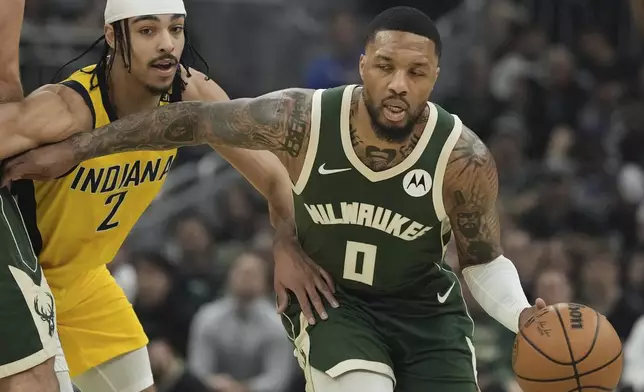 Milwaukee Bucks' Damian Lillard gets past Indiana Pacers' Andrew Nembhard during the first half of Game 1 of the NBA playoff basketball game Sunday, April 21, 2024, in Milwaukee. (AP Photo/Morry Gash)