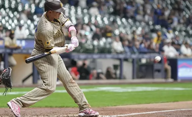 San Diego Padres' Manny Machado hiyts an RBI single during the fifth inning of a baseball game against the Milwaukee Brewers Monday, April 15, 2024, in Milwaukee. (AP Photo/Morry Gash)