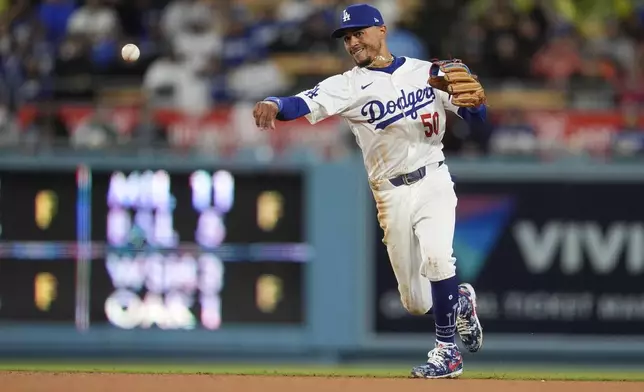 Los Angeles Dodgers shortstop Mookie Betts throws out San Diego Padres' Jackson Merrill at first base on a ground ball during the fourth inning of a baseball game Saturday, April 13, 2024, in Los Angeles. (AP Photo/Marcio Jose Sanchez)