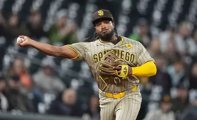 San Diego Padres third baseman Eguy Rosario throws to first base for the out on Colorado Rockies' Jake Cave to end the eighth inning of a baseball game Tuesday, April 23, 2024, in Denver. (AP Photo/David Zalubowski)