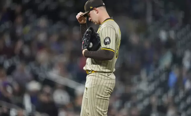San Diego Padres starting pitcher Michael King adjusts his cap after giving up a grand slam to Colorado Rockies' Brendan Rodgers during the fourth inning of a baseball game Tuesday, April 23, 2024, in Denver. (AP Photo/David Zalubowski)