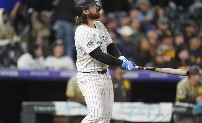 Colorado Rockies' Brendan Rodgers watches his grand slam off San Diego Padres starting pitcher Michael King during the fourth inning of a baseball game Tuesday, April 23, 2024, in Denver. (AP Photo/David Zalubowski)