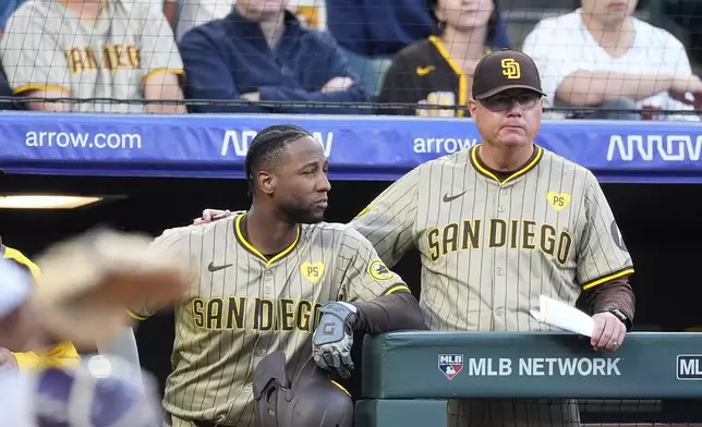 San Diego Padres' Jurickson Profar, left, confers with manager Mike Shildt during the second inning of the team's baseball game against the Colorado Rockies on Wednesday, April 24, 2024, in Denver. (AP Photo/David Zalubowski)