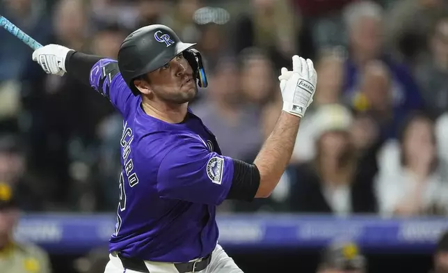 Colorado Rockies' Sean Bouchard follows the flight of his double off San Diego Padres pitcher Robert Suarez in the ninth inning of a baseball game Monday, April 22, 2024, in Denver. (AP Photo/David Zalubowski)