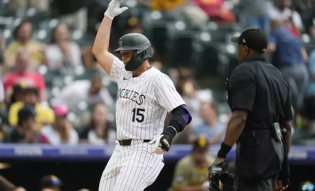 Colorado Rockies' Hunter Goodman gestures as he crosses home plate after hitting a three-run home run off San Diego Padres relief pitcher Wandy Peralta in the eighth inning of a baseball game Thursday, April 25, 2024, in Denver. (AP Photo/David Zalubowski)