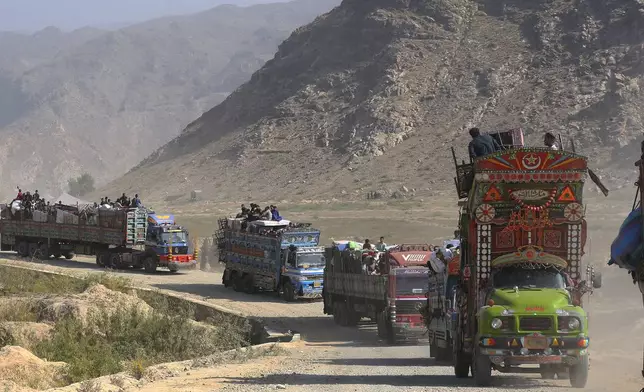 FILE - A convey of trucks carrying Afghan families drive toward a border crossing point in Torkham, Pakistan, Tuesday, Oct. 31, 2023. For more than 1 million Afghans who fled war and poverty to Pakistan, these are uncertain times. Since Pakistan announced a crackdown on migrants last year, some 600,000 have been deported and at least a million remain in Pakistan in hiding. They've retreated from public view, abandoning their jobs and rarely leaving their neighborhoods out of fear they could be next. It's harder for them to earn money, rent accommodation, buy food or get medical help because they run the risk of getting caught by police or being reported to authorities by Pakistanis. (AP Photo/Muhammad Sajjad, File)