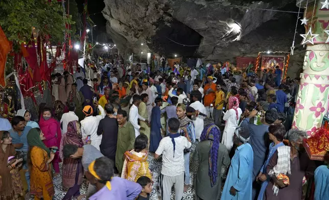 Hindu devotees attend an annual festival in an ancient cave temple of Hinglaj Mata in Hinglaj in Lasbela district in the Pakistan's southwestern Baluchistan province, Friday, April 26, 2024. More than 100,000 Hindus are expected to climb mud volcanoes and steep rocks in southwestern Pakistan as part of a three-day pilgrimage to one of the faith's holiest sites. (AP Photo/Junaid Ahmed)