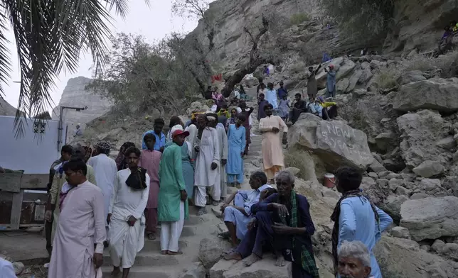 Hindu devotees climb stairs to reach atop an ancient cave temple of Hinglaj Mata to attend an annual festival in Hinglaj in Lasbela district in the Pakistan's southwestern Baluchistan province, Friday, April 26, 2024. More than 100,000 Hindus are expected to climb mud volcanoes and steep rocks in southwestern Pakistan as part of a three-day pilgrimage to one of the faith's holiest sites. (AP Photo/Junaid Ahmed)