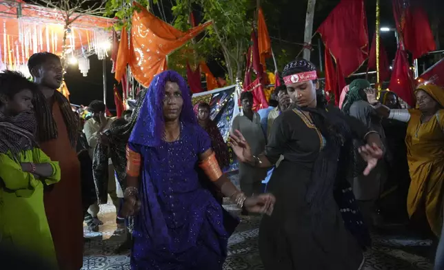 Hindu devotees dance during an annual festival in an cave temple of Hinglaj Mata in Hinglaj in Lasbela district in Pakistan's southwestern Baluchistan province, Friday, April 26, 2024. More than 100,000 Hindus are expected to climb mud volcanoes and steep rocks in southwestern Pakistan as part of a three-day pilgrimage to one of the faith's holiest sites. (AP Photo/Junaid Ahmed)
