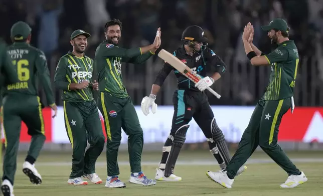 Pakistan's Mohammad Amir, third left, celebrates with teammates after taking the wicket of New Zealand's Tim Robinson, second right, during the second T20 international cricket match between Pakistan and New Zealand, in Rawalpindi, Pakistan, Saturday, April 20, 2024. (AP Photo/Anjum Naveed)