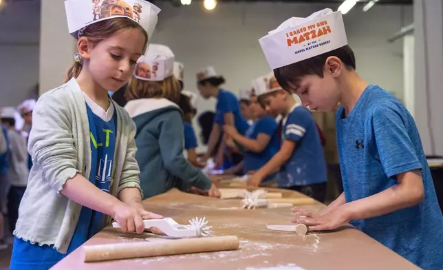 First graders from Milton Gottesman Jewish Day School of the Nation's Capital, make matzah during a "Matzah Factory" field trip to the JCrafts Center for Jewish Life and Tradition in Rockville, Md., Thursday, April 18, 2024, ahead of the Passover holiday which begins next Monday evening. To be kosher for Passover the dough has to be prepared and cooked all within 18 minutes and not allowed to rise. (AP Photo/Jacquelyn Martin)