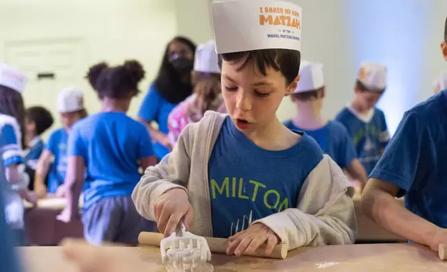 Ethan Pressberg, 6, a first grader at Milton Gottesman Jewish Day School of the Nation's Capital, uses a tool to make holes in dough for matzah during a "Matzah Factory" field trip at the JCrafts Center for Jewish Life and Tradition in Rockville, Md., Thursday, April 18, 2024, ahead of the Passover holiday which begins next Monday evening. To be kosher for Passover the dough has to be prepared and cooked all within 18 minutes and not allowed to rise. (AP Photo/Jacquelyn Martin)