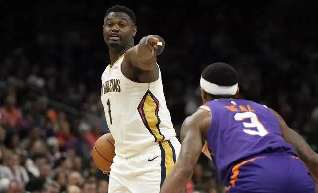 New Orleans Pelicans forward Zion Williamson, left, points to a teammate in front of Phoenix Suns guard Bradley Beal (3) during the first half of an NBA basketball game, Sunday, April 7, 2024, in Phoenix. (AP Photo/Rick Scuteri)