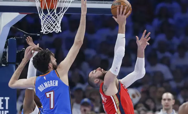 New Orleans Pelicans center Jonas Valanciunas, right, shoots a reverse shot against Oklahoma City Thunder forward Chet Holmgren (7) during the first half in Game 2 of an NBA basketball first-round playoff series, Wednesday, April 24, 2024, in Oklahoma City. (AP Photo/Nate Billings)
