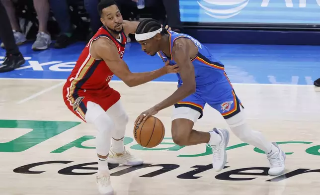 Oklahoma City Thunder guard Shai Gilgeous-Alexander, right, drives against New Orleans Pelicans guard CJ McCollum, left, during the first half in Game 2 of an NBA basketball first-round playoff series, Wednesday, April 24, 2024, in Oklahoma City. (AP Photo/Nate Billings)