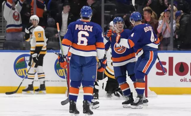 New York Islanders' Samuel Bolduc, right, celebrates his goal with Casey Cizikas, center, during the third period of the team's NHL hockey game against the Pittsburgh Penguins, Wednesday, April 17, 2024, in Elmont, N.Y. (AP Photo/Seth Wenig)
