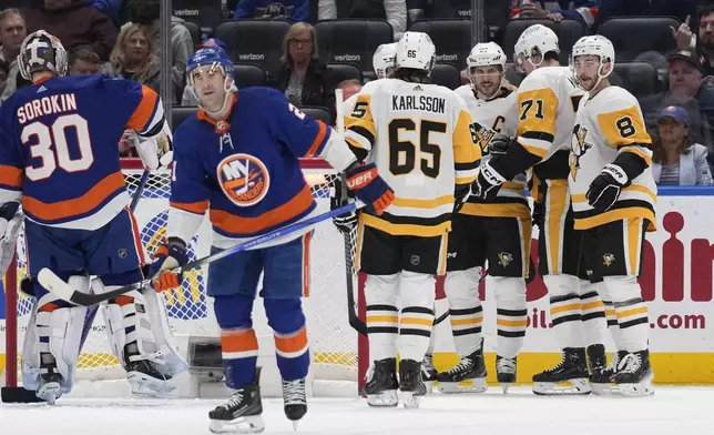 Pittsburgh Penguins' Evgeni Malkin (71) celebrates his goal against the New York Islanders with teammates, including Sidney Crosby, third from right, during the second period of an NHL hockey game Wednesday, April 17, 2024, in Elmont, N.Y. (AP Photo/Seth Wenig)