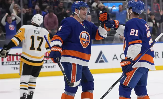 New York Islanders' Kyle Palmieri, right, celebrates his goal against the Pittsburgh Penguins with Samuel Bolduc during the second period of an NHL hockey game Wednesday, April 17, 2024, in Elmont, N.Y. (AP Photo/Seth Wenig)