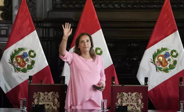 Peru's President Dina Boluarte waves as she arrives to attend a press conference at Government Palace in Lima, Peru, Friday, April 5, 2024. Authorities are investigating on whether she illegally received hundreds of thousands of dollars in cash, luxury watches and jewelry. (AP Photo/Martin Mejia)