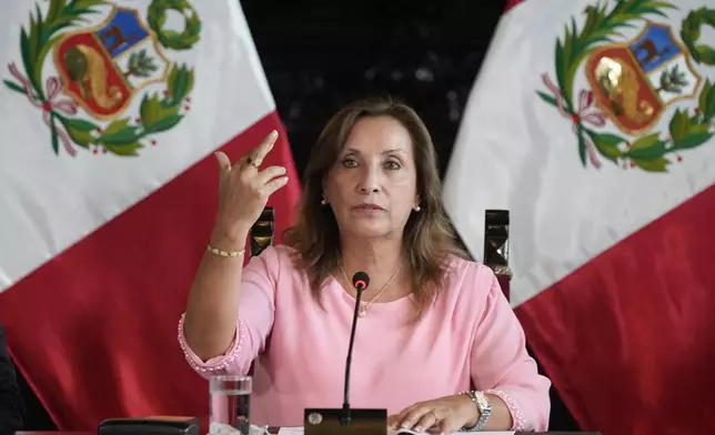 Peru's President Dina Boluarte holds up her hand to show the ring and bracelet she is wearing, during a press conference at Government Palace, in Lima, Peru, Friday, April 5, 2024. Authorities are investigating on whether she illegally received hundreds of thousands of dollars in cash, luxury watches and jewelry. (AP Photo/Martin Mejia)