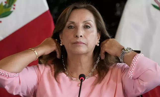 Peru's President Dina Boluarte shows her jewelry during a press conference at Government Palace in Lima, Peru, Friday, April 5, 2024. Authorities are investigating on whether she illegally received hundreds of thousands of dollars in cash, luxury watches and jewelry. (AP Photo/Martin Mejia)