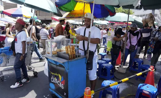 Venezuelan Giovanny Tovar waits for customers at his tequeños or fried breaded cheese sticks' street cart, in Lima, Peru, Saturday, April 13, 2024. Tovar is one of millions of Venezuelans living abroad who will not be able to cast his vote in the July 28th presidential election. (AP Photo/Martin Mejia)