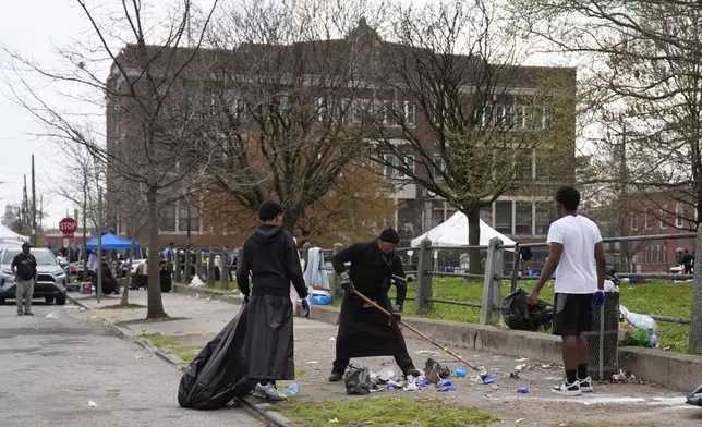 People clean up debris at the scene of a shooting at an Eid al-Fitr event in Philadelphia, Wednesday, April 10, 2024. (AP Photo/Matt Rourke)